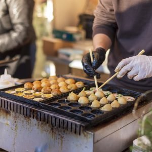 Process of cooking takoyaki balls. Japanese snacks and street food at the festival